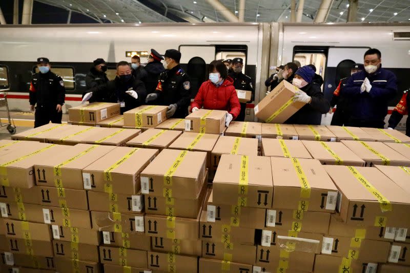 Police officers and workers wearing face masks transport medical supplies arriving by train at the Wuhan railway station following an outbreak of the new coronavirus