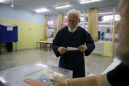 A Greek orthodox priest casts his ballot in a general election at a polling station in Athens, Greece, September 20, 2015. REUTERS/Alkis Konstantinidis