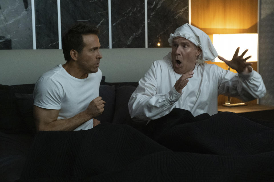 This image released by Apple TV+ shows Ryan Reynolds, left, and Will Ferrell in a scene from "Spirited." (Claire Folger/Apple TV+ via AP)