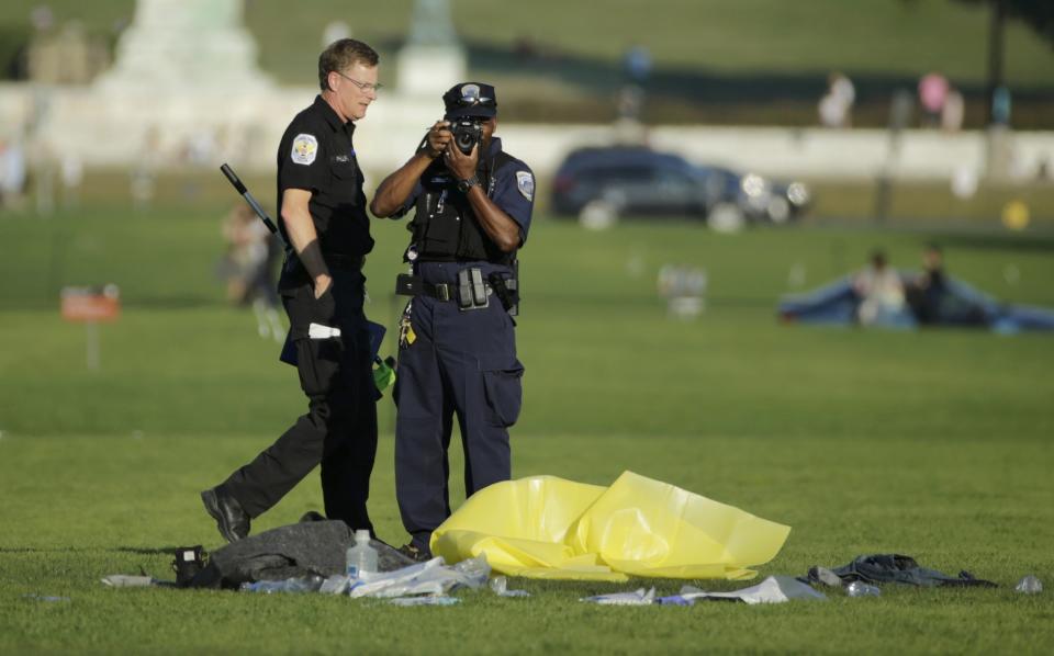 Police officers investigate the scene where a man set himself on fire in front of the U.S. Capitol on the U.S. National Mall in Washington