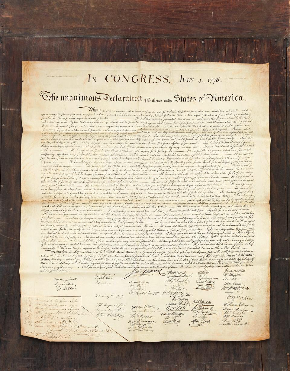 A copy of the Declaration of Independence with a wooden background.