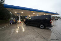 Vehicles fill up at a petrol station after an outbreak of panic buying in the UK, in Manchester, England, Monday, Sept. 27, 2021. British Prime Minister Boris Johnson is said to be considering whether to call in the army to deliver fuel to petrol stations as pumps ran dry after days of panic buying. ( AP Photo/Jon Super)