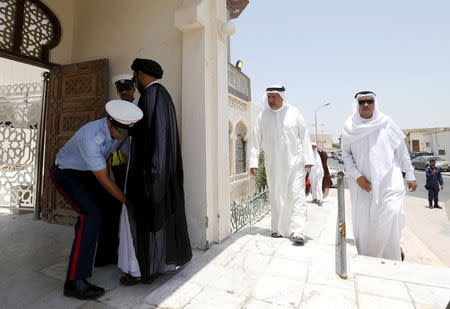 A police officer frisks a man arriving for Friday prayers at the Al A'ali Grand Mosque, where joint Sunni and Shi'ites prayers are to be held to show solidarity and co-existence between the two sects of Islam, ahead of Friday prayers in Al A'ali south of Manama, July 3, 2015. REUTERS/Hamad I Mohammed