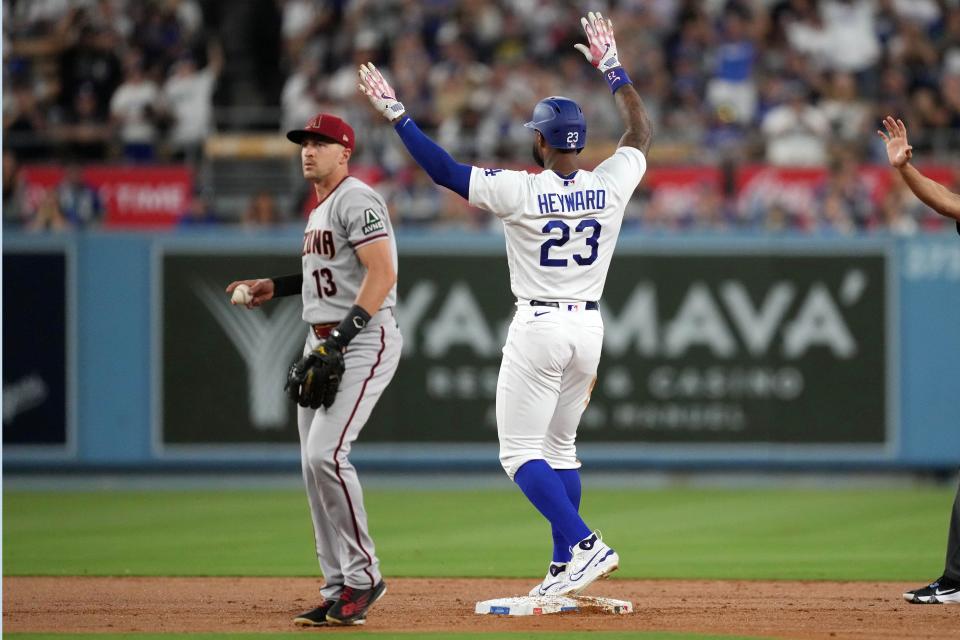 Aug 29, 2023; Los Angeles, California, USA; Los Angeles Dodgers right fielder Jason Heyward (23) gestures after hitting a double in the first inning as Arizona Diamondbacks shortstop Nick Ahmed (13) reacts at Dodger Stadium. Mandatory Credit: Kirby Lee-USA TODAY Sports