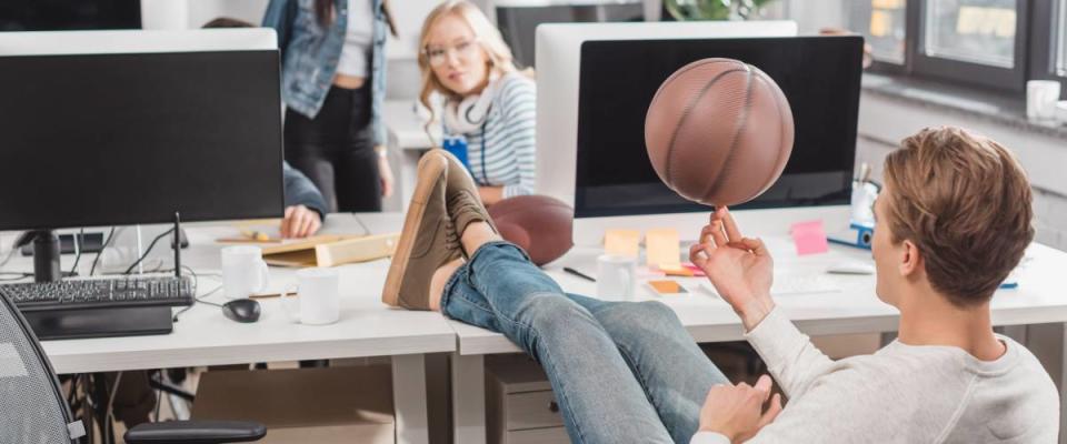 women watching at man spinning ball at office