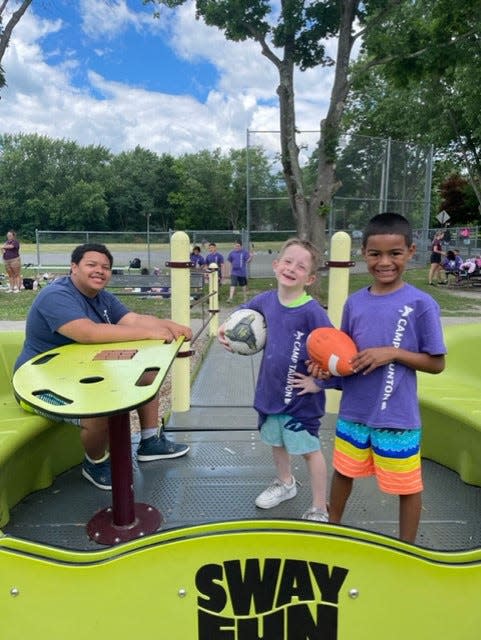 Camp Taunton counselor Izael Cruz works with campers Nolan Green and Qadir Brown as they play at Hopewell Park.