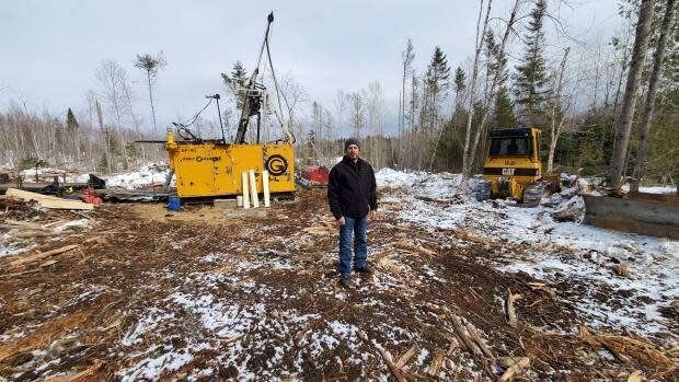 Ryan Bridges stands on his neighbour Millen Nixon's land, where mining operations to determine how much gold is underneath have led to muddy roads and cleared forest. Both men say mining operations threaten their farms.