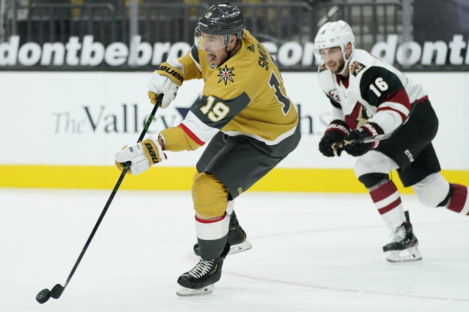 Vegas Golden Knights right wing Reilly Smith (19) passes around Arizona Coyotes center Derick Brassard (16) during the third period of an NHL hockey game Wednesday, Jan. 20, 2021, in Las Vegas. (AP Photo/John Locher)