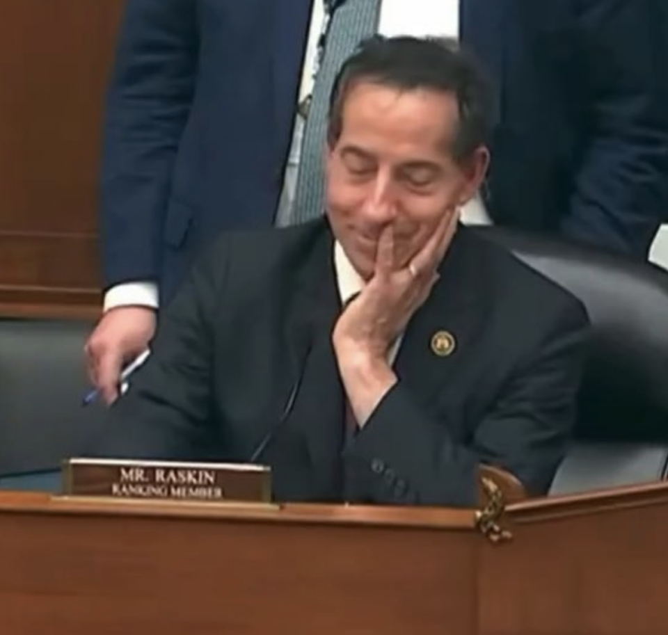 Jamie Raskin seated at a desk, resting his chin on his hand, with a nameplate reading "Mr. Raskin - Ranking Member" visible in the foreground