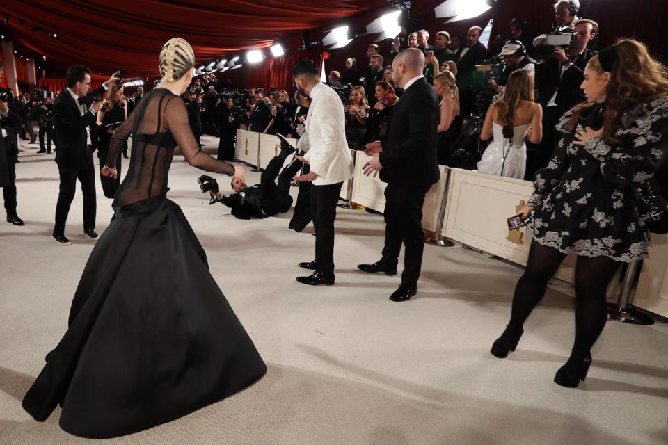 Lady Gaga reacts on the champagne-colored red carpet when a photographer falls (REUTERS)