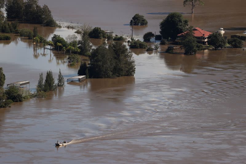 A boat navigates the swollen Hawkesbury River during a flood event northwest of Sydney