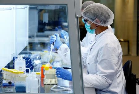 Two lab technicians perform tests at the laboratory of the ICMP (International Commission on Missing Persons) Headquarters in the Hague, the Netherlands, October 24, 2017. REUTERS/Michael Kooren