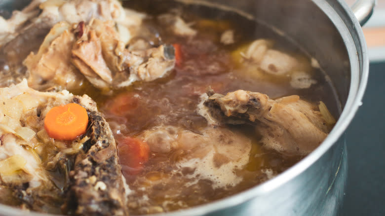 Meat, bones, carrots in pot 