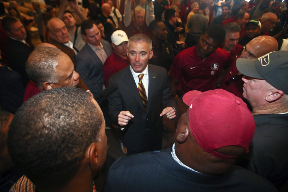 FILE - In this Sunday, Dec. 8, 2019, file photo, new Florida State NCAA college football head coach Mike Norvell talks to football staffers after a news conference, in Tallahassee, Fla. Norvell is taking over a Seminoles program that has struggled while he was helping to build Memphis into a Group of Five power. Florida State got in three practices before the new coronavirus outbreak shut down college sports and upended nearly everything else. (AP Photo/Phil Sears, File)