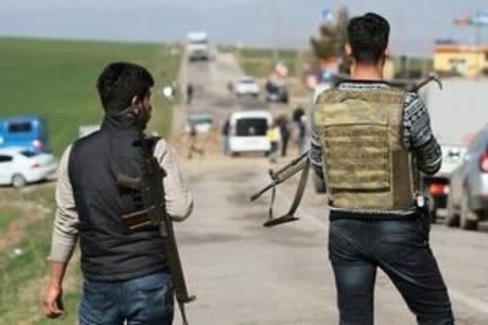 Security officers stand guard near the site where a military vehicle was damaged by a remote control bomb, near Diyarbakir, Turkey February 18, 2016. A bomb detonated by remote control killed seven Turkish security force members travelling in a military vehicle in southeast Turkey on Thursday, security sources said, a day after a car bomb attack in the capital Ankara killed 28 people. REUTERS/Sertac Kayar