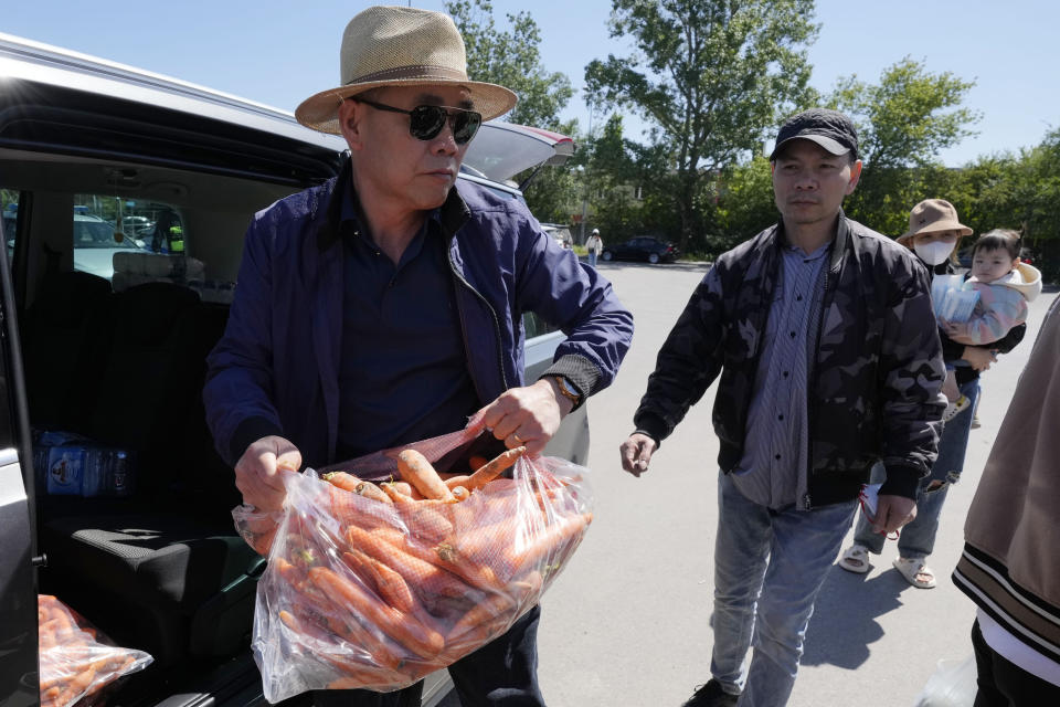 Members of Poland's Vietnamese community collect food donations, in Warsaw, Poland, Wednesday, May 15, 2024. A weekend fire in a shopping center in Warsaw dealt tragedy to many members of Poland's Vietnamese community. People lost entire livelihoods and say they don't know how they will manage to make a living. (AP Photo/Czarek Sokolowski)