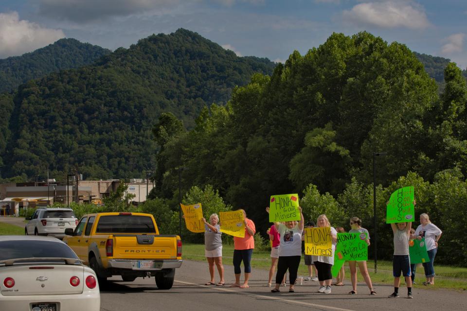 Family members hold signs along Highway 421 in Harlan in support of coal miners affected by the bankruptcy of the Blackjewel coal company. July 18, 2019