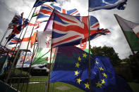 Flags, including a European flag, are blown by the wind after being placed there by Anti-Brexit remain in the European Union supporters near the Houses of Parliament in London, Wednesday, Oct. 15, 2019. The European Union and Britain sought to keep their chances of reaching a full Brexit divorce deal by Thursday's EU summit alive on Wednesday despite legal issues centering on the Irish border frustrating negotiators. (AP Photo/Matt Dunham)