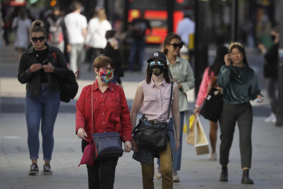 Shoppers wear masks on Oxford Street in London, Monday, Sept. 21, 2020. Britain's top medical advisers have painted a grim picture of exponential growth in illness and death if nothing is done to control the second wave of coronavirus infections, laying the groundwork for the government to announce new restrictions later this week. (AP Photo/Kirsty Wigglesworth)