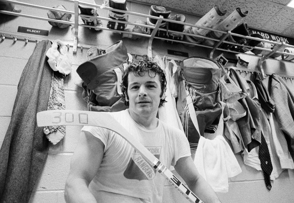 FILE - In this March 25, 1974, file photo, New York Rangers right wing Rod Gilbert displays a hockey stick marked with a "300," the total number of goals he has scored in his career, in the Rangers' locker room in New York. Gilbert, the Hall of Fame right wing who starred for the Rangers and helped Canada win the 1972 Summit Series, had died. He was 80. Gilbert’s family confirmed the death to Rangers on Sunday, Aug. 22, 2021. (AP Photo/John Lent, File)