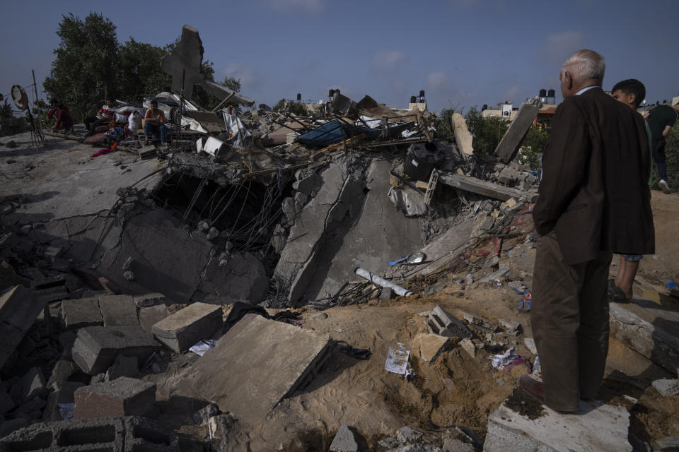 Palestinos inspeccionan los restos de una vivienda alcanzada por un ataque aéreo israelí en Beit Lahia, en el norte de la Franja de Gaza, el 12 de mayo de 2023. (AP Foto/Fatima Shbair)