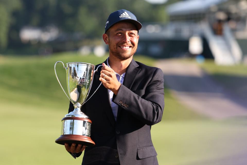 Xander Schauffele holds up the Travelers Championship trophy after winning the tournament last year.