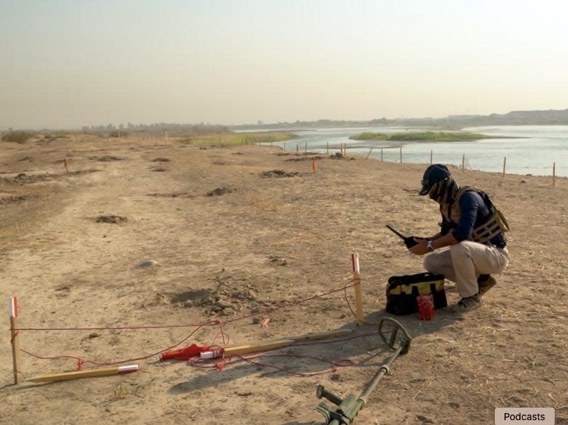 Falah Hassan uses a metal detector to find IEDs