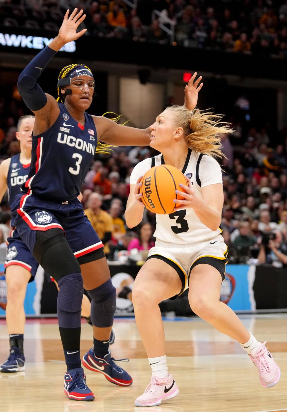 Iowa guard Sydney Affolter (3) drives to the basket as Connecticut forward Aaliyah Edwards (3) defends during Friday's national semifinal game at Rocket Mortgage FieldHouse.