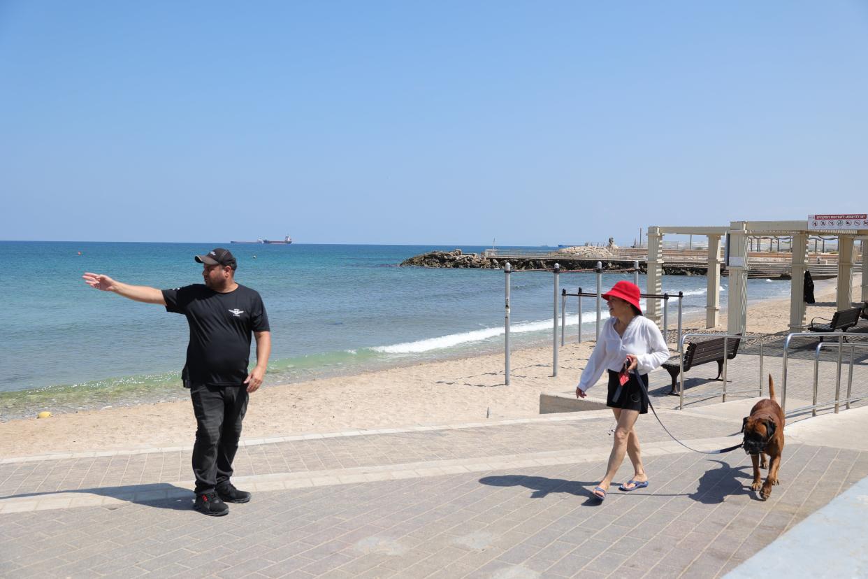 A municipality inspector asks a woman to get out of the sea in the northern city of Haifa, Israel (EPA)