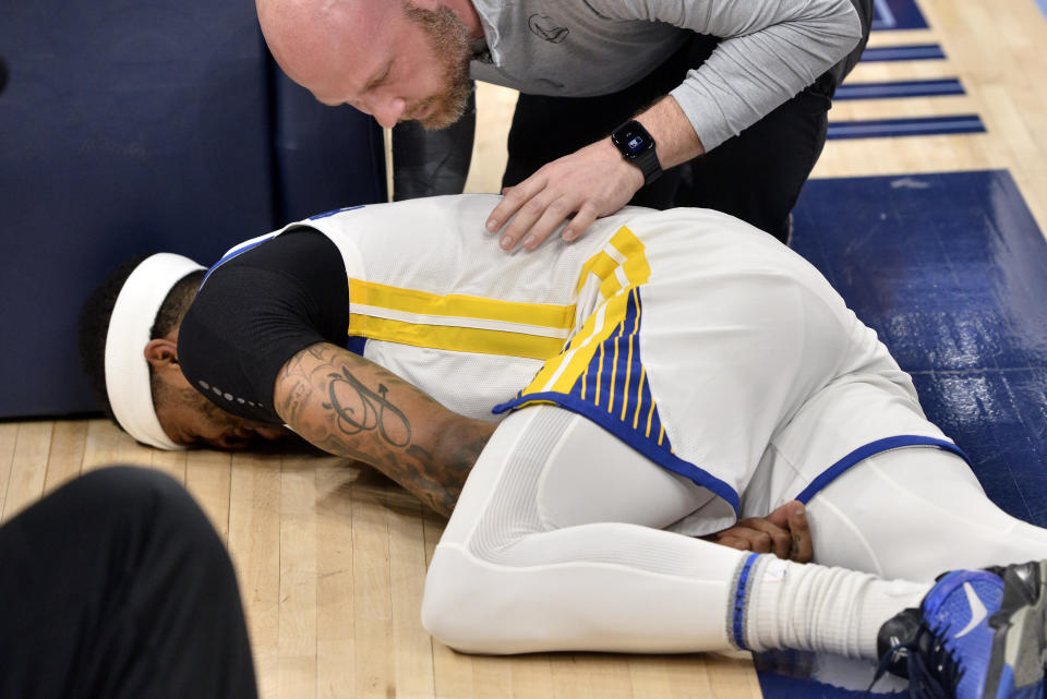 Golden State Warriors guard Gary Payton II (0) lies on the court after being fouled in the first half during Game 2 of a second-round NBA basketball playoff series against the Memphis Grizzlies Tuesday, May 3, 2022, in Memphis, Tenn. (AP Photo/Brandon Dill)