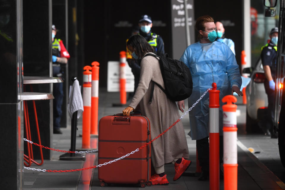 Passengers are seen disembarking and entering a hotel quarantine facility at Pan Pacific Melbourne. Source: AAP