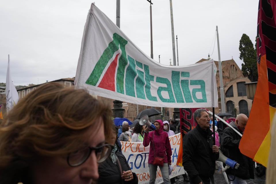 Trabajadores de Alitalia se reúnen con manifestantes durante una huelga de transporte convocada por el sindicato COBAS, en el centro de Roma, el lunes 11 de octubre de 2021. El sindicato COBAS, que representa a todos los trabajadores públicos, convocó una huelga a nivel nacional para exigir mejoras salariales, condiciones laborales, seguridad y pensiones. (AP Foto/Gregorio Borgia)