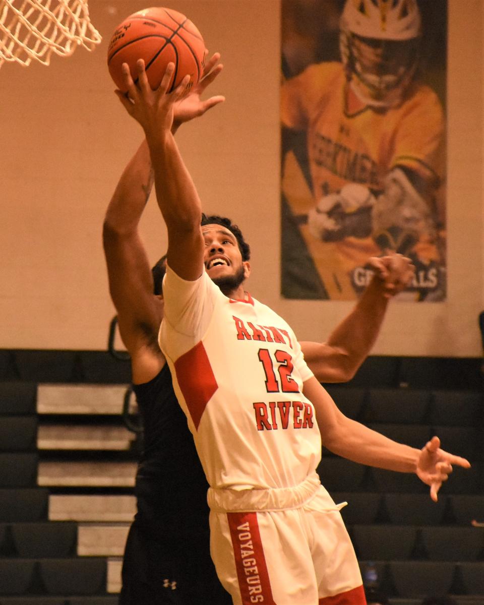 Jose Martino lays the ball up for a Minnesota North College-Rainy River basket with Michael Nkwogu defending from behind for Joliet Junior College Wednesday. Rainy River won the game and advanced to meet Herkimer College, the tournament host, in Wednesday's quarterfinals.