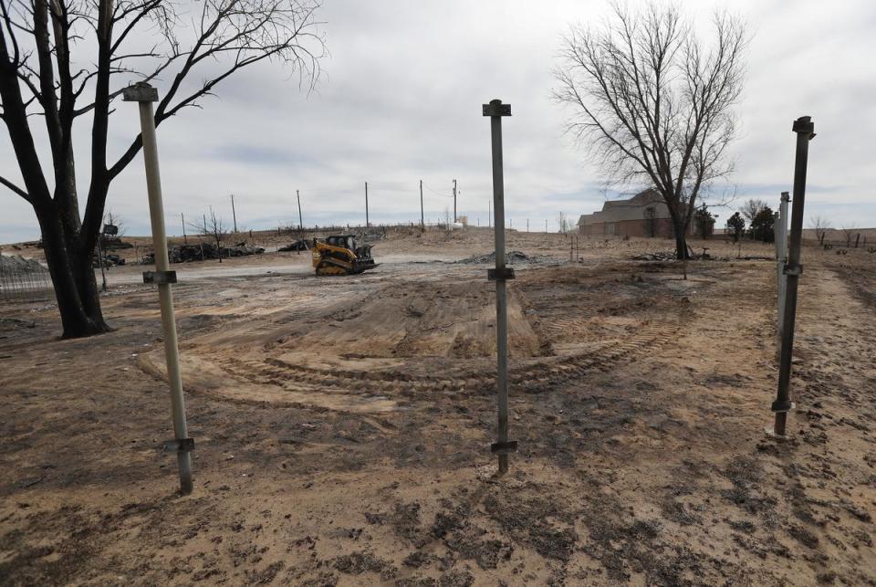 A Baptist Southern Convention volunteer drives a Skid Steer to clear property owned by Melanie McQuiddy. These fence posts are all that remain of her property.. Canadian, Tx. residents were cleaning up and recovering from the massive wild fires that burned much of the northern Texas panhandle.
