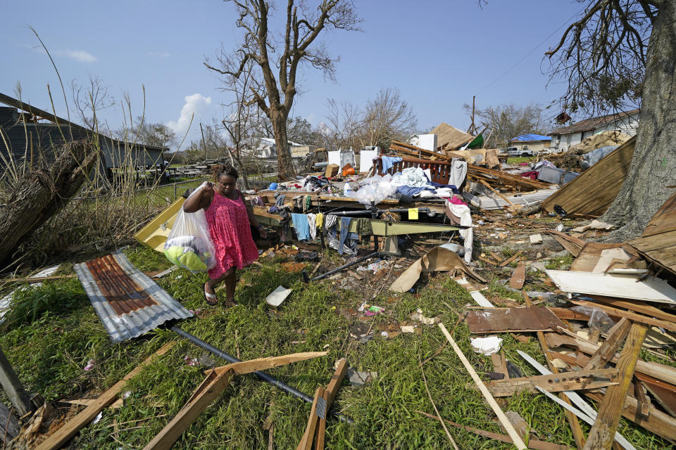 Cruz Palma carries a bag of her belongings while sifting through what remains of her destroyed home, in the aftermath of Hurricane Ida, Thursday, Sept. 2, 2021, in Golden Meadow, La. (AP Photo/David J. Phillip)