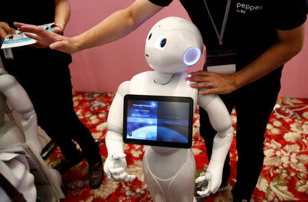 A man touches SoftBank humanoid robot known as Pepper as he demonstrates its translation function at Pepper World 2016 Summer during SoftBank World 2016 conference in Tokyo, Japan, July 21, 2016. REUTERS/Kim Kyung-Hoon