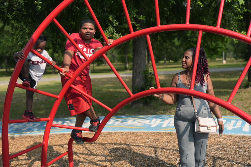 Tamika Davis, right, spends time with her children Lionel Jr., left, and Matthew, 11, at MLK Park in San Antonio, Thursday, May 30, 2024. Davis said friends and family watched her kids for most of her doctor visits during treatment last year for colon cancer. But she couldn't afford additional childcare, and she didn't know where to look for assistance. (AP Photo/Eric Gay)