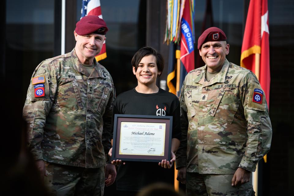 Maj. Gen. Pat Work, left, and Command Sgt. Maj. Randolph Delapena, right, pose with the middle school 82nd Airborne Division Junior Paratrooper of Year Michael Adame on Tuesday, May 21, 2024, on Fort Liberty.