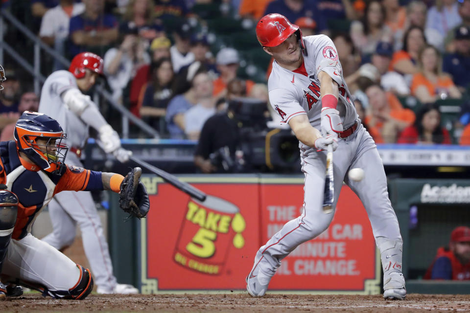 Los Angeles Angels' Mike Trout, right, connects for a two-un home run in front of Houston Astros catcher Martin Maldonado, left, during the sixth inning of a baseball game Friday, Sept. 9, 2022, in Houston. (AP Photo/Michael Wyke)