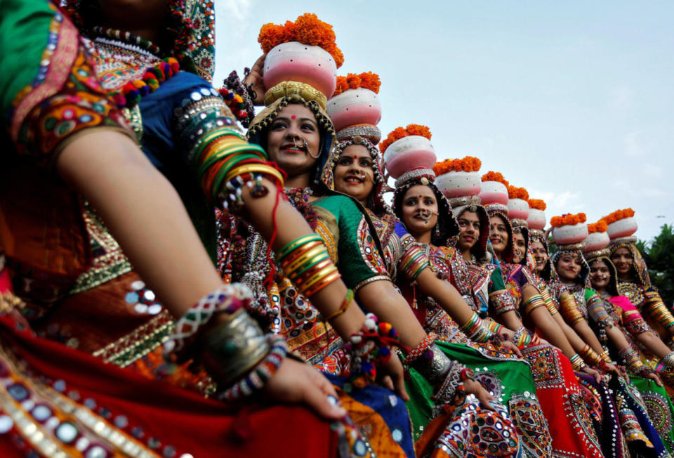 Women dressed in traditional attire pose after taking part in rehearsals for Garba, a folk dance, ahead of Navratri, a festival when devotees worship the Hindu goddess Durga, in Ahmedabad