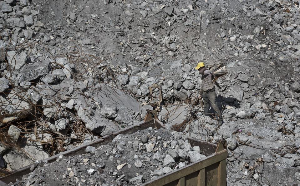 A worker continues the long process of removing rubble from the damaged Westgate Mall in Nairobi, Kenya Tuesday, Jan. 21, 2014. Court officials and four handcuffed ethnic Somalis accused of aiding the gunmen who attacked Nairobi's Westgate Mall in Sept. 2013, walked through the heavily damaged shopping center on Tuesday led by Chief Magistrate Daniel Ochenja, to help the court visualize the mall's layout for the ongoing trial of the four men. (AP Photo/Ben Curtis)