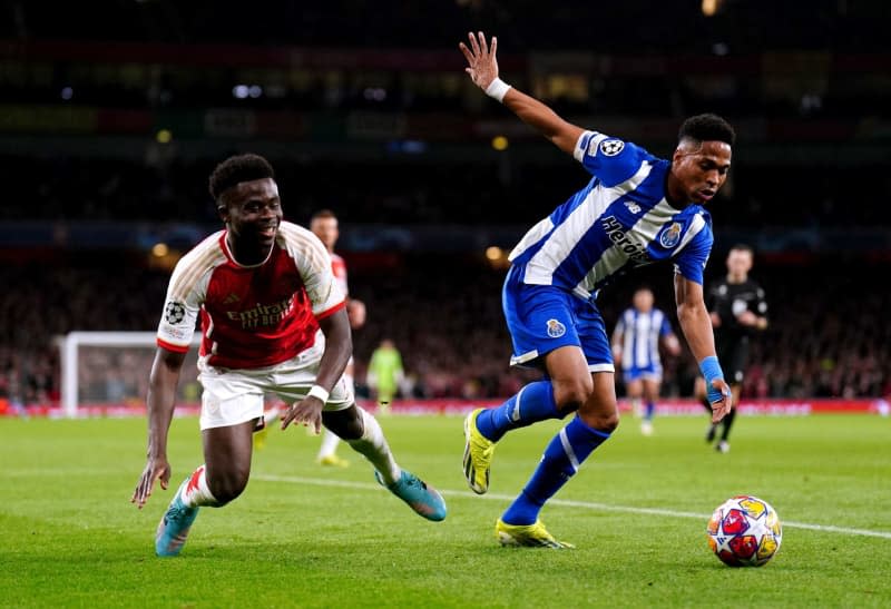Arsenal's Bukayo Saka (L) goes down whilst battling for the ball with FC Porto's Wendell during the UEFA Champions League Round of 16, second leg soccer match between Arsenal and FC Porto at the Emirates Stadium. Zac Goodwin/PA Wire/dpa