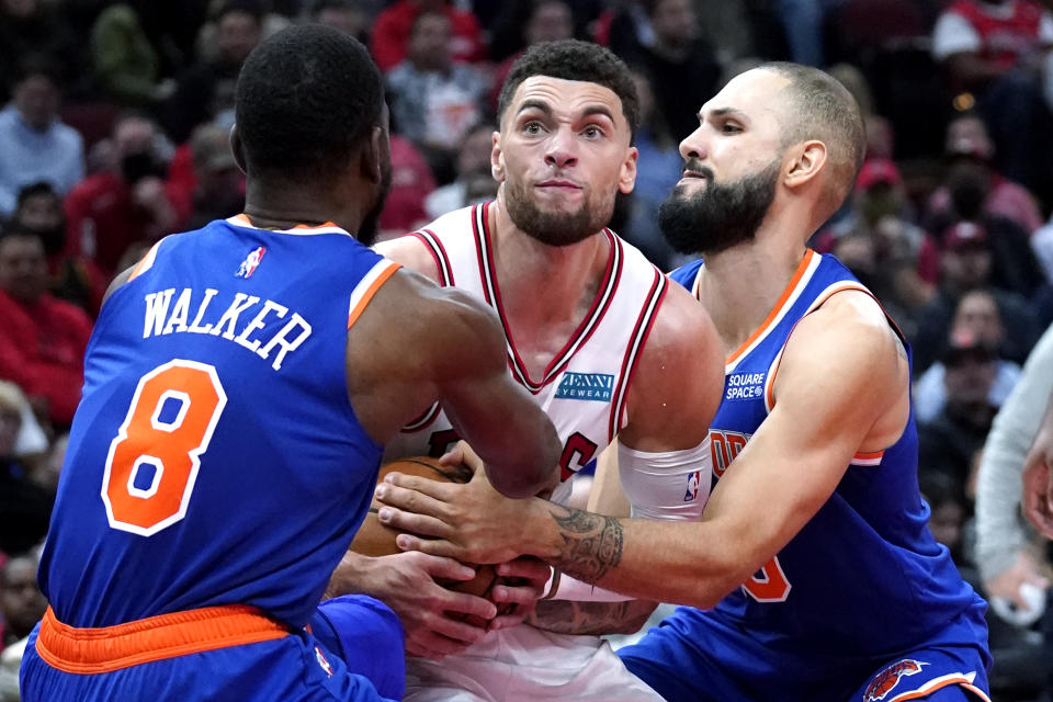 Chicago Bulls guard Zach LaVine, center, battles for the ball against New York Knicks guards Kemba Walker, left, and Evan Fournier during the second half of an NBA basketball game Thursday, Oct. 28, 2021, in Chicago. (AP Photo/Nam Y. Huh)