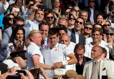 Jul 6, 2014; London, United Kingdom; Novak Djokovic (SRB) climbs into his box with his coaching team and Boris Becker to celebrate after recording match point in his match against Roger Federer (SUI) on day 13 of the 2014 Wimbledon Championships at the All England Lawn and Tennis Club. Susan Mullane-USA TODAY Sports