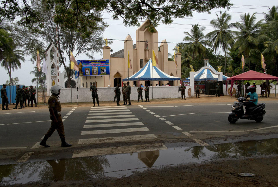 Soldiers guard outside St. Joseph's church, Tuesday, April 30, 2019, in Thannamunai, Sri Lanka. This small village in eastern Sri Lanka has held likely the first Mass since Catholic leaders closed all their churches for fear of more attacks after the Easter suicide bombings that killed over 250 people. (AP Photo/Gemunu Amarasinghe)