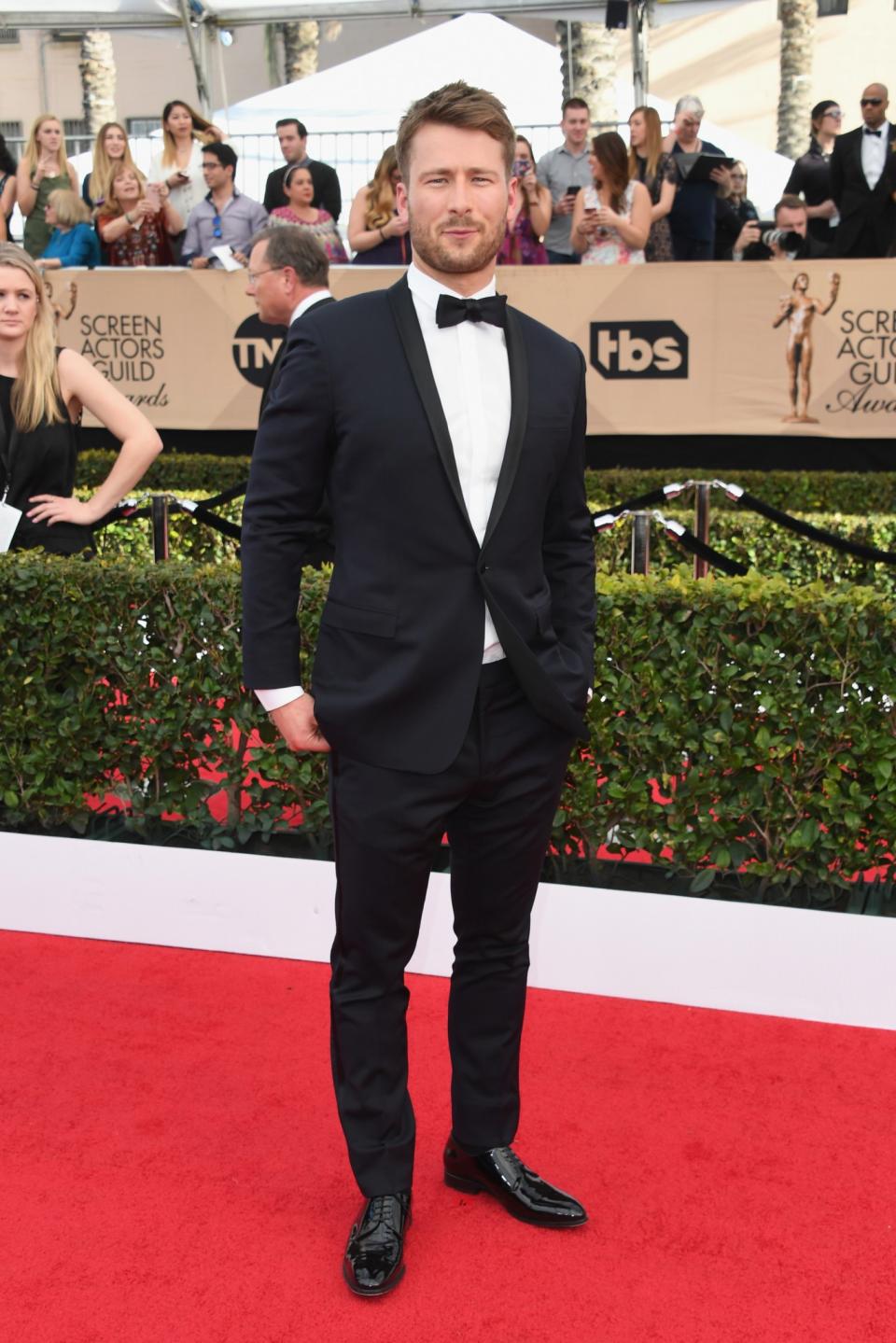 Glen Powell pairs a smirk with a black tuxedo