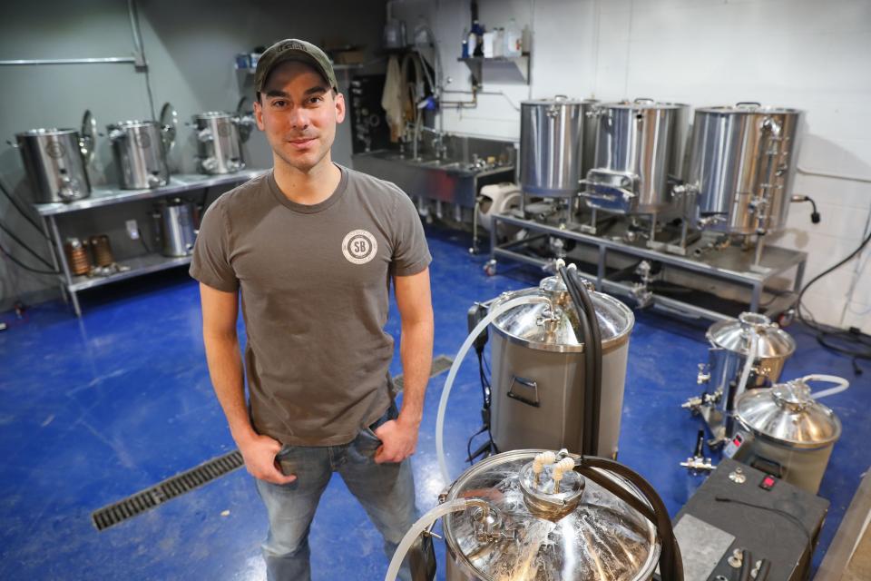 Spike Brewing owner Ben Caya displays a test brewery set up at the company in 2019. The company's growth has been driven by both the craft beer explosion as well as increased interest in home brewing.