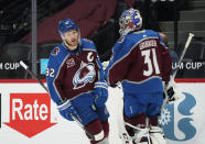 FILE - In this April 30, 2021, file photo, Colorado Avalanche left wing Gabriel Landeskog (92) skates past goaltender Philipp Grubauer during the first period of the team's NHL hockey game against the San Jose Sharks in Denver. Avalanche general manager Joe Sakic still is not sure the team will be able to bring back Landeskog and Grubauer.“I don’t know,” Sakic said. “We’re hopeful we can come to terms, as well, and have them signed and to be part of us.” (AP Photo/David Zalubowski, File)