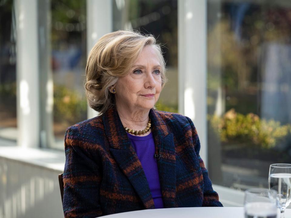 Hillary Clinton sits at a table.