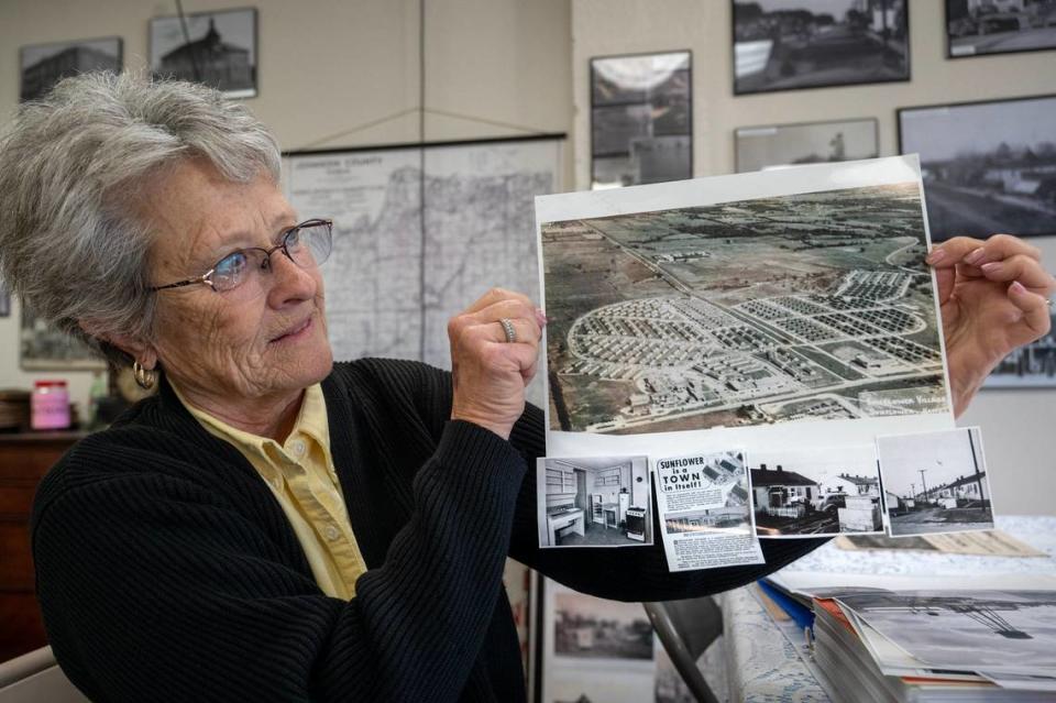 Kathy Ross, president of the De Soto Kansas Historical Society, displays early photos of the Sunflower Village housing complex, built in 1943 to house workers at the Sunflower Ordnance Works.